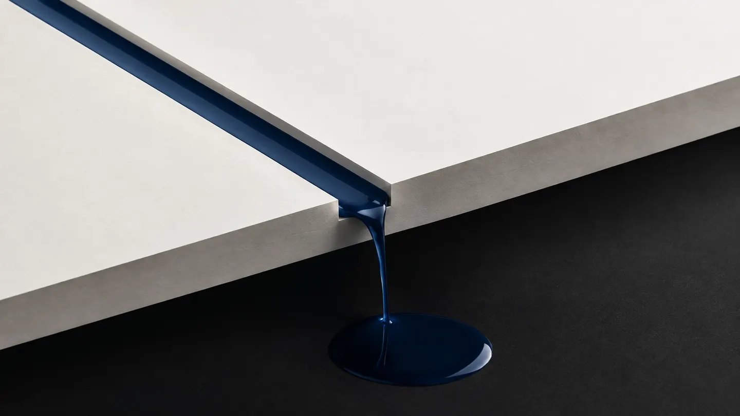 Abstract blue ink flowing through a narrow gap from a light surface into a dark pool, representing fees leaving a business